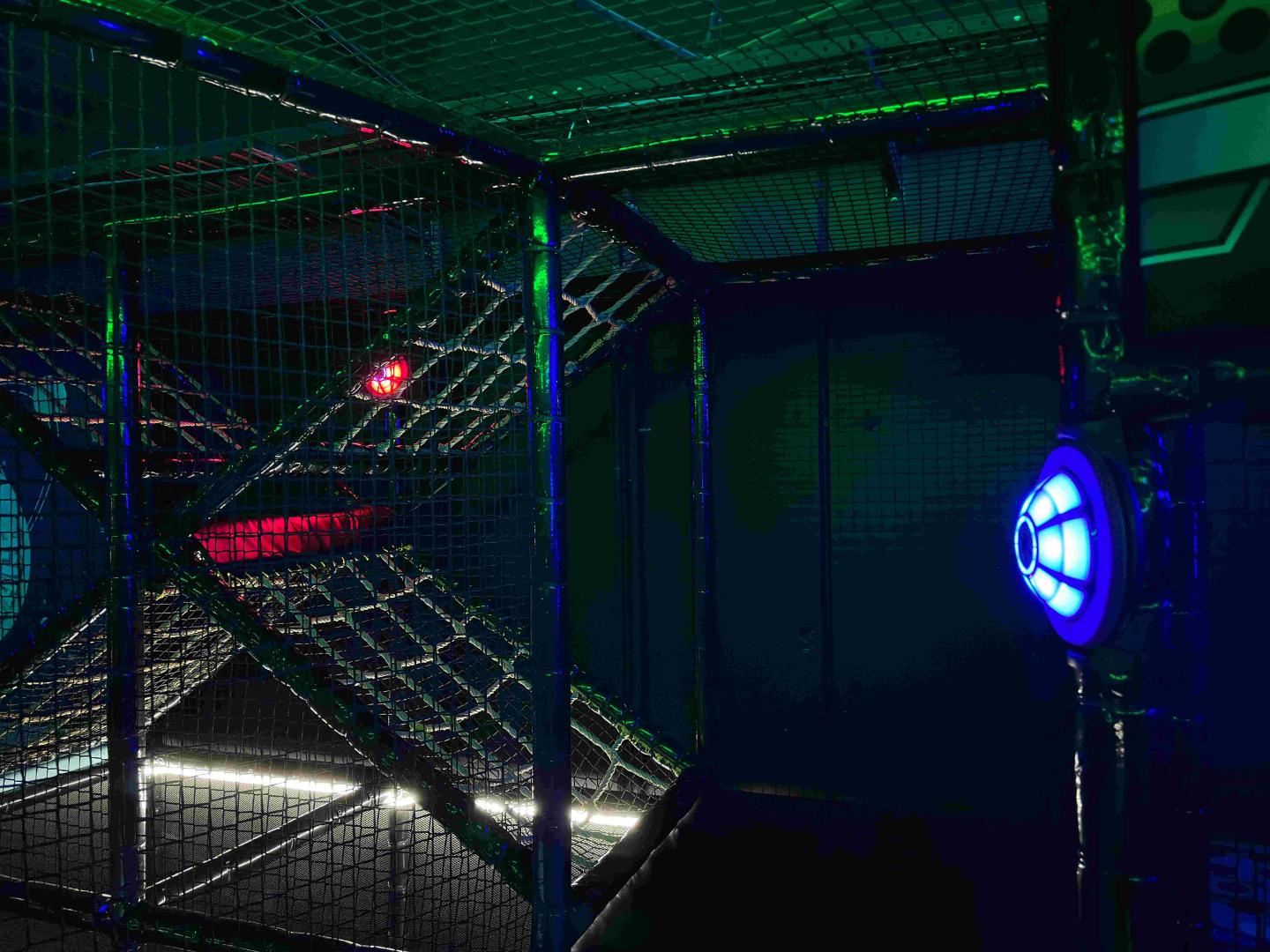 Indoor speelpark met netten en interactieve JB Tag Solutions spot met blauwe verlichting.