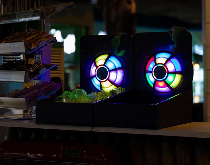 JB-TAG oplaadstation met oplichtende LED-schijven en speelbandjes op een balie in een indoor speelhal, klaar voor gebruik door kinderen.