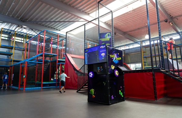 Tag&Run scorebord en interactief spel geplaatst in een indoor speelparadijs met kleurrijke klimrekken en trampolines. Creëer meer speelplezier en uitdaging voor jouw bezoekers met het Tag&Run systeem.