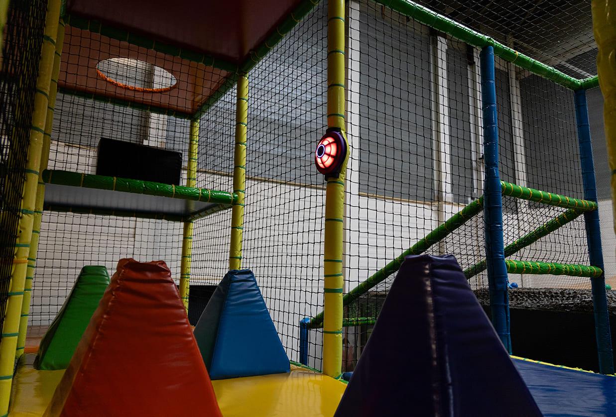 Rood oplichtende JB-TAG sensor van JB Tag Solutions gemonteerd in een indoor speelstructuur met zachte obstakels en klimelementen